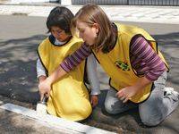 young women in yellow vests painting