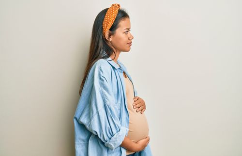 A woman holds her pregnant belly