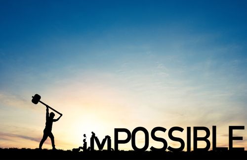 a figure with a hammer breaking the word “impossible”