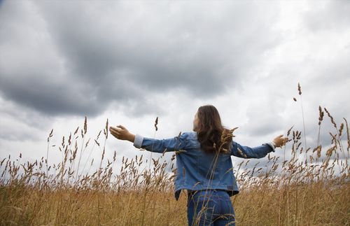 Woman in field with arms outstretched