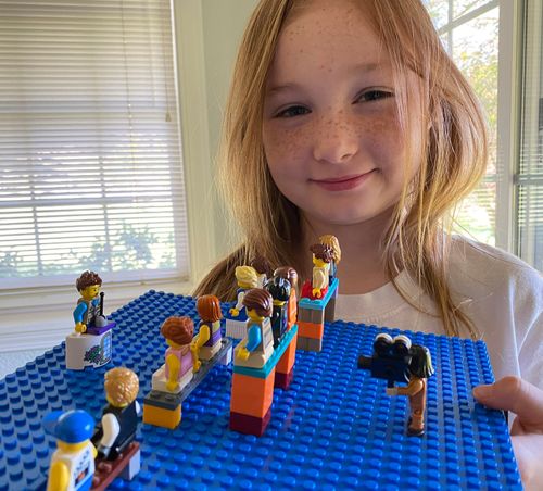 Lucy M. with a scene of general conference made from plastic blocks