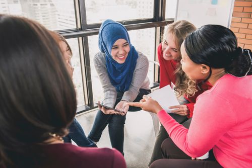 women sitting in circle enjoying sharing stories in group meeting