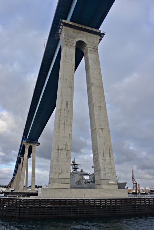 A view of large pillars holding up the Coronado Bridge with water down below in San Diego, California.