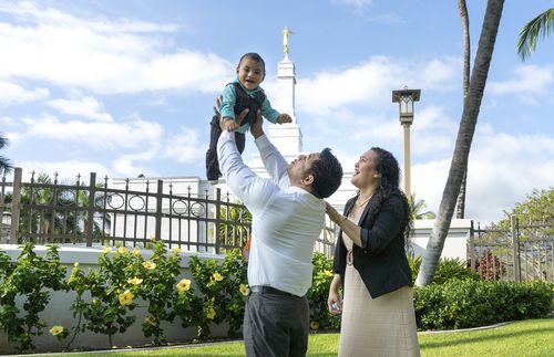 couple with child in front of the temple