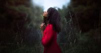 A young woman is kneeling in prayer.