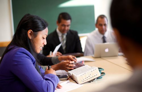 a woman studying the scriptures with a group of people