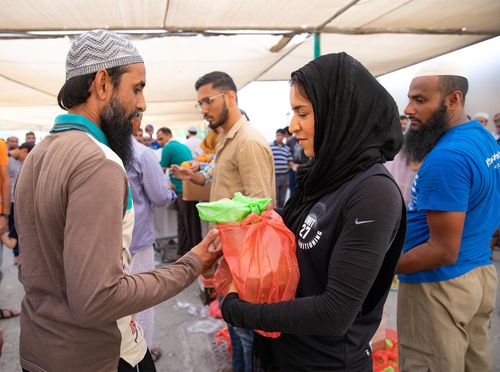 volunteers distributing food packages to workers