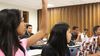 young woman raising her hand in class