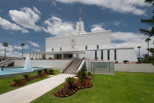 A front view of the Mexico City Mexico Temple in the daytime, with green lawns and a water feature in the foreground.