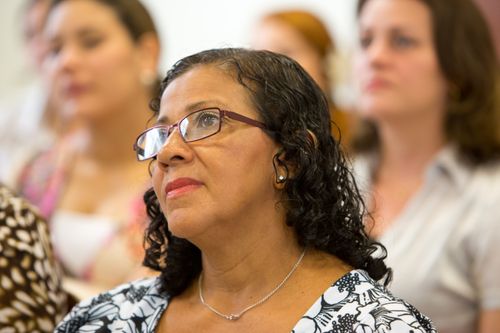 A woman sits and listens to a lesson in a Relief Society meeting in Brazil.