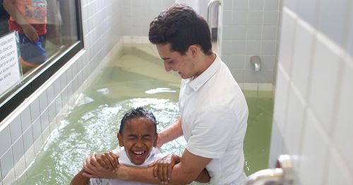 Young boy in Madagascar is baptized in font.