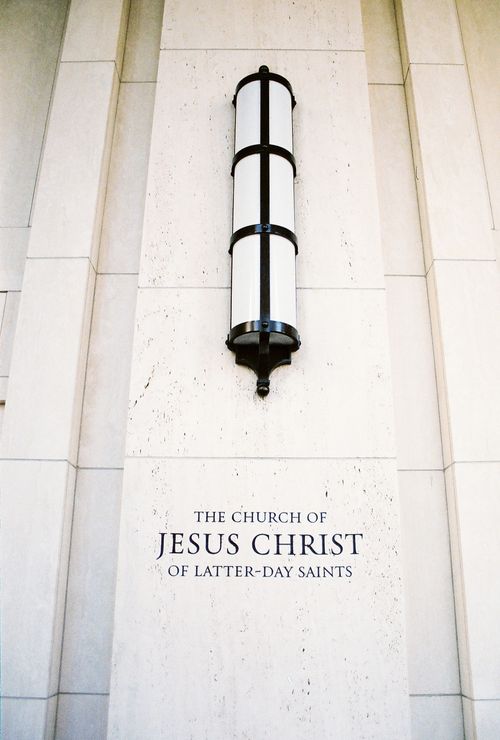A close-up view of a lamp and an engraving on the Manhattan New York Temple exterior that reads, “The Church of Jesus Christ of Latter-day Saints.”