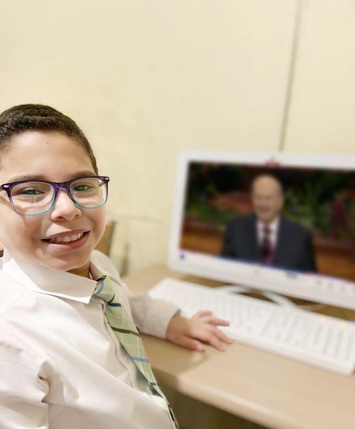 boy watching conference on computer screen