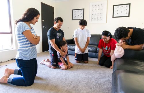 무릎 꿇고 기도하는 가족