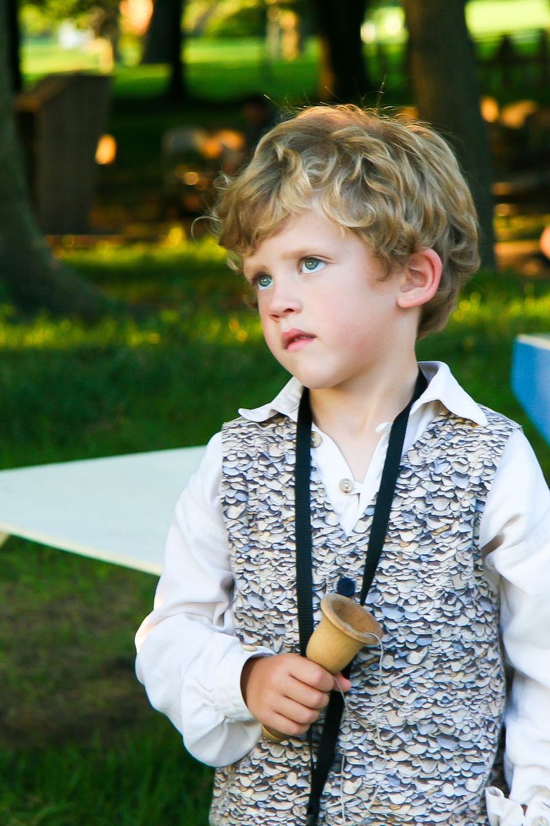A young actor in the Nauvoo Pageant holding a wooden bell.