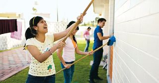 youth doing service cleaning the exterior of a building