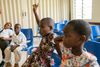 children in class with their hands raised