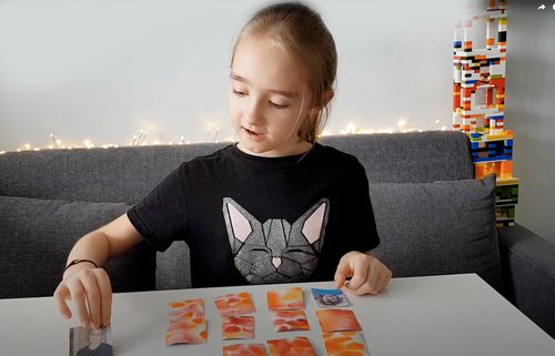 girl playing matching games with pictures of her family