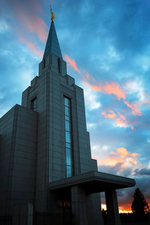 The front of the Vancouver British Columbia Temple after sunset, with a view of the entrance and the spire with the angel Moroni.