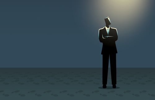 silhouetted man standing alone under a light source