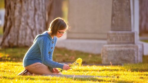 Girl laying flowers on grave