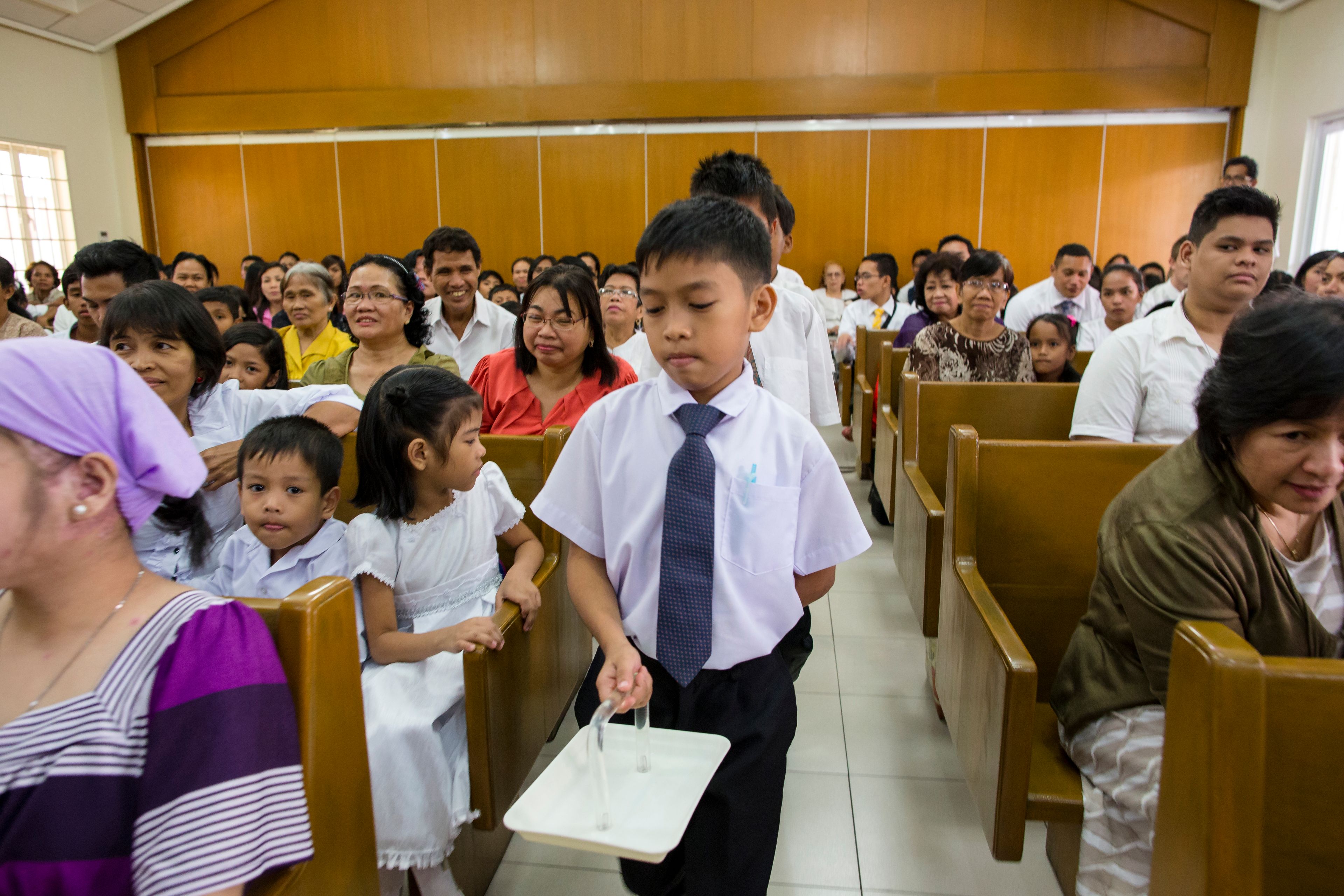 A row of deacons passing the sacrament in a congregation in the Philippines.