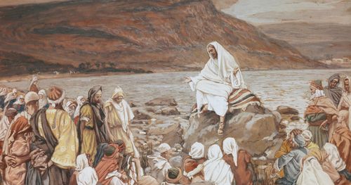 Jesucristo sentado en una roca a orillas del mar de Galilea. Hay muchas personas reunidas alrededor de Él. La gente está escuchando a Cristo predicar. (Marcos 4:1) (Lucas 5:1).