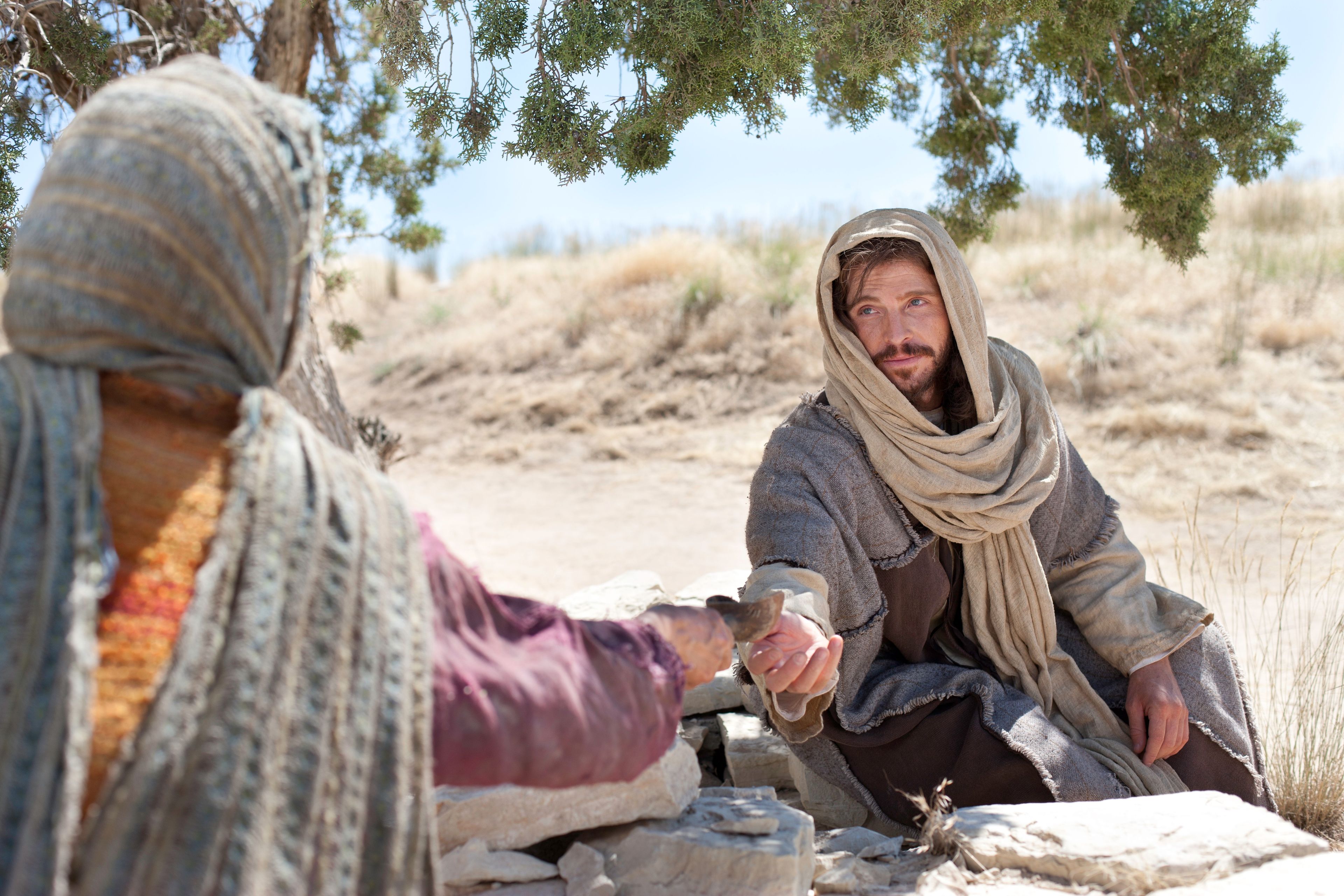 Cristo extiende Su mano para aceptar el agua del pozo que le ofrece la mujer samaritana.