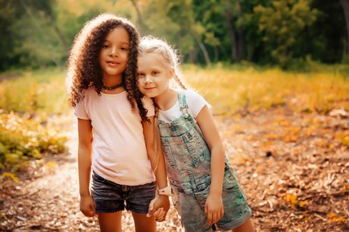 two young girls standing hand in hand