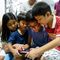 Children in the Philippines look at an IPad or tablet together.