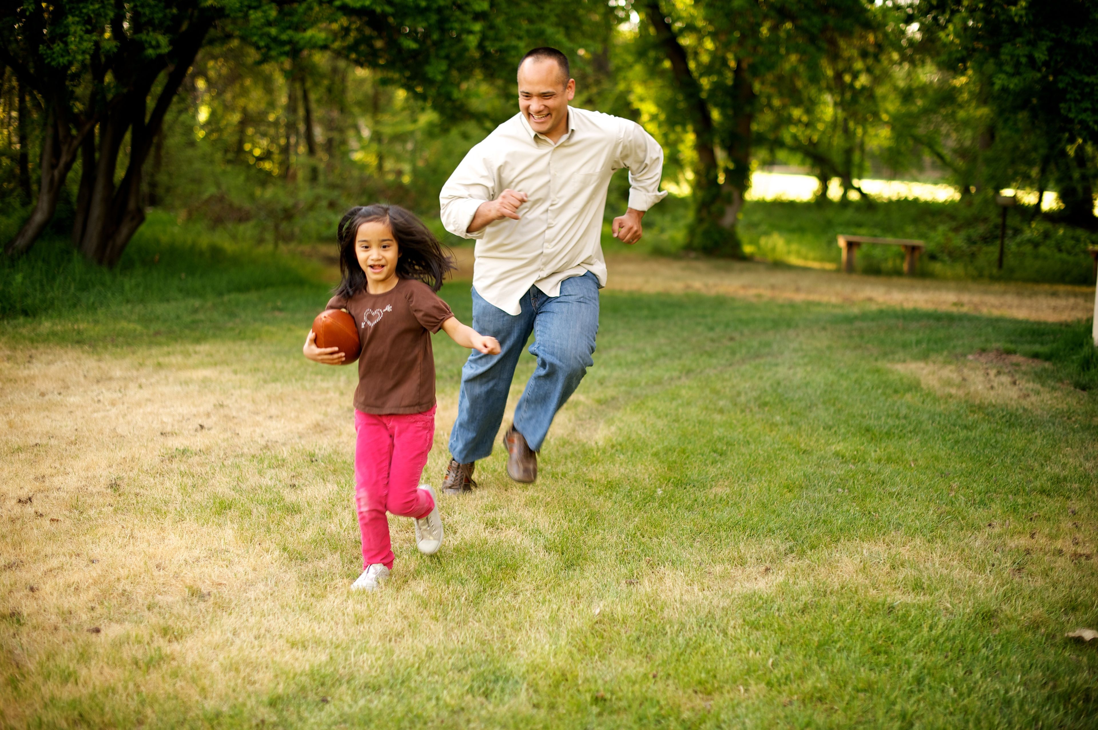 A father plays football with his daughter.