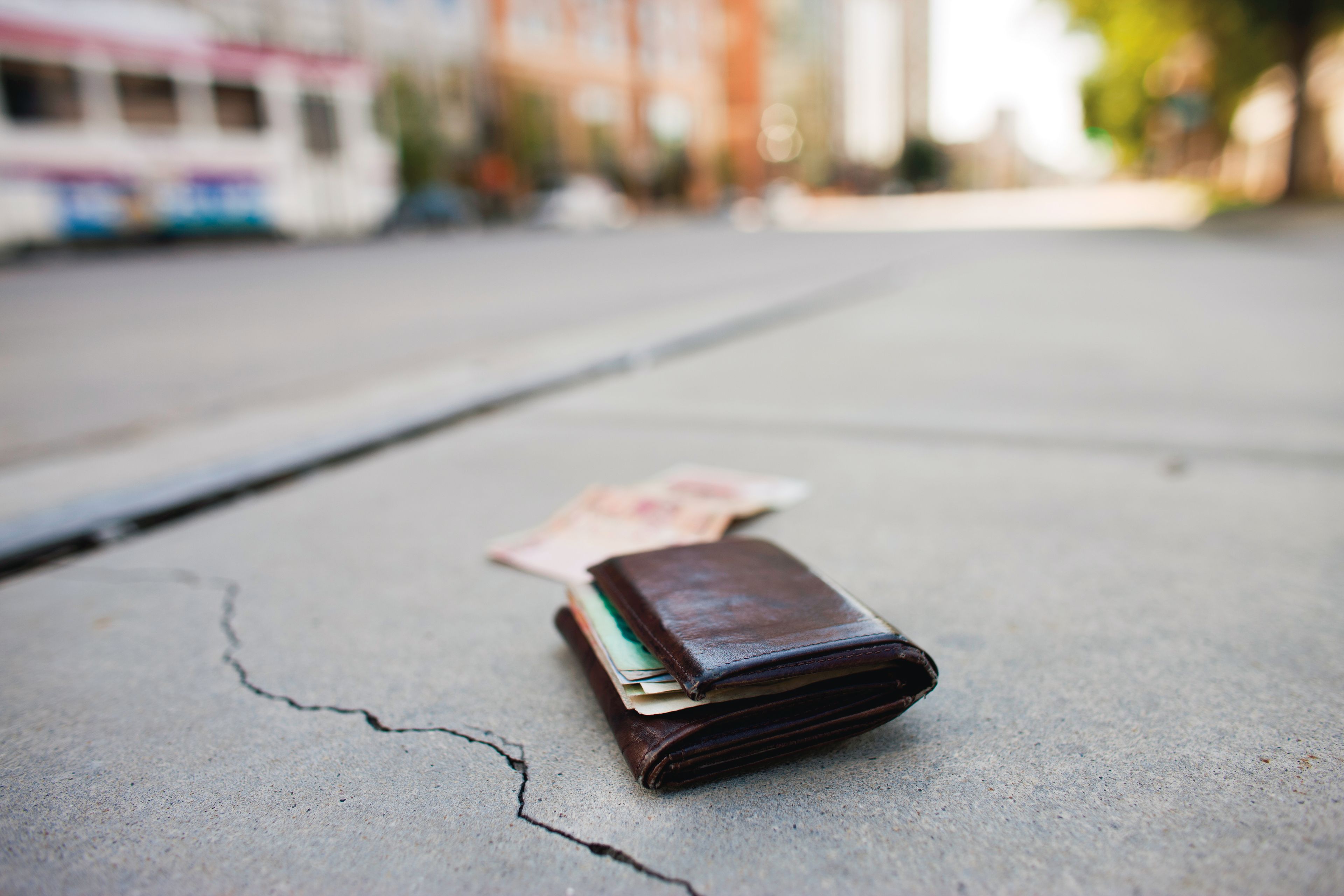 A man’s wallet lying on the sidewalk.
