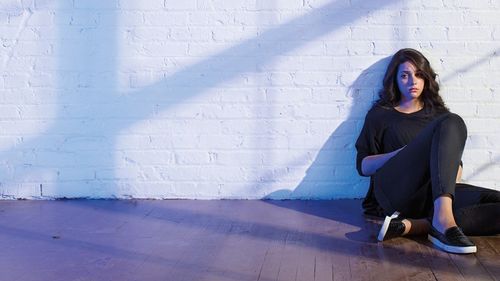 youth sitting against the wall sad