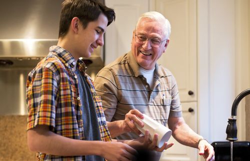 Grandfather and grandson washing dishes