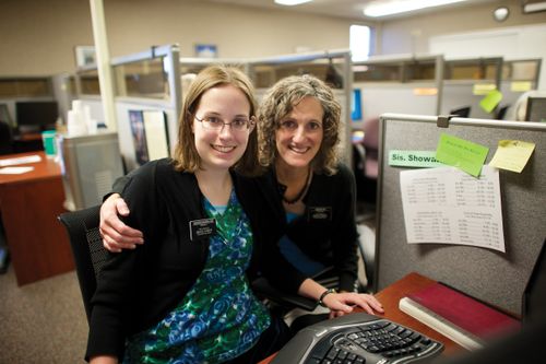 Two female Church-service missionaries serving together in an office.