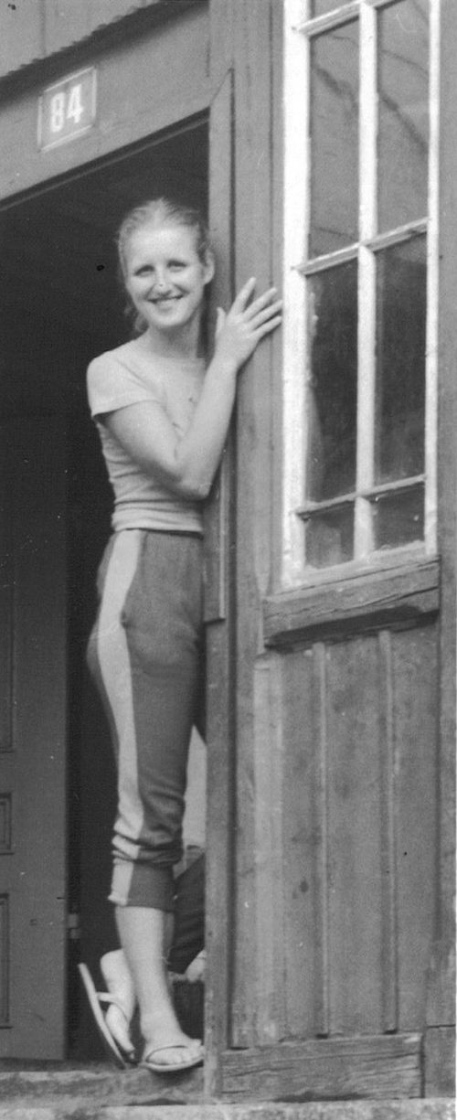 Olga Kovářová leans against a doorframe and smiles.