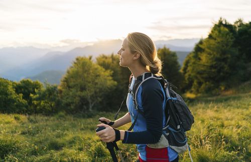 young woman hiking in the mountains at sunrise