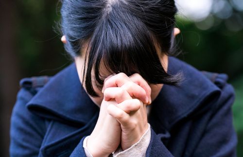 young woman praying outside