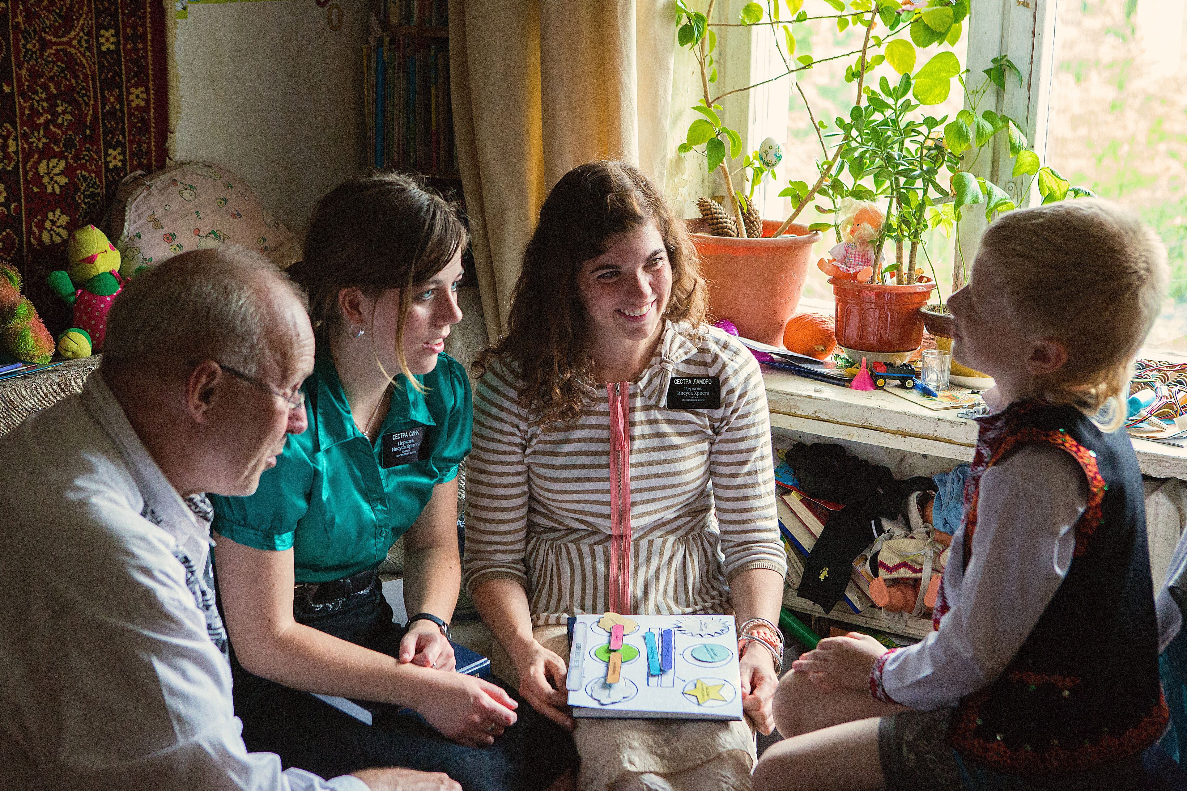 A young boy being taught by two sister missionaries in Ukraine.