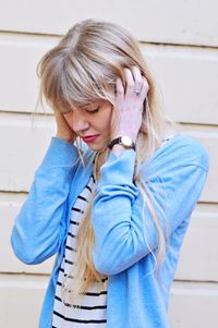 young woman with hands gripping her head