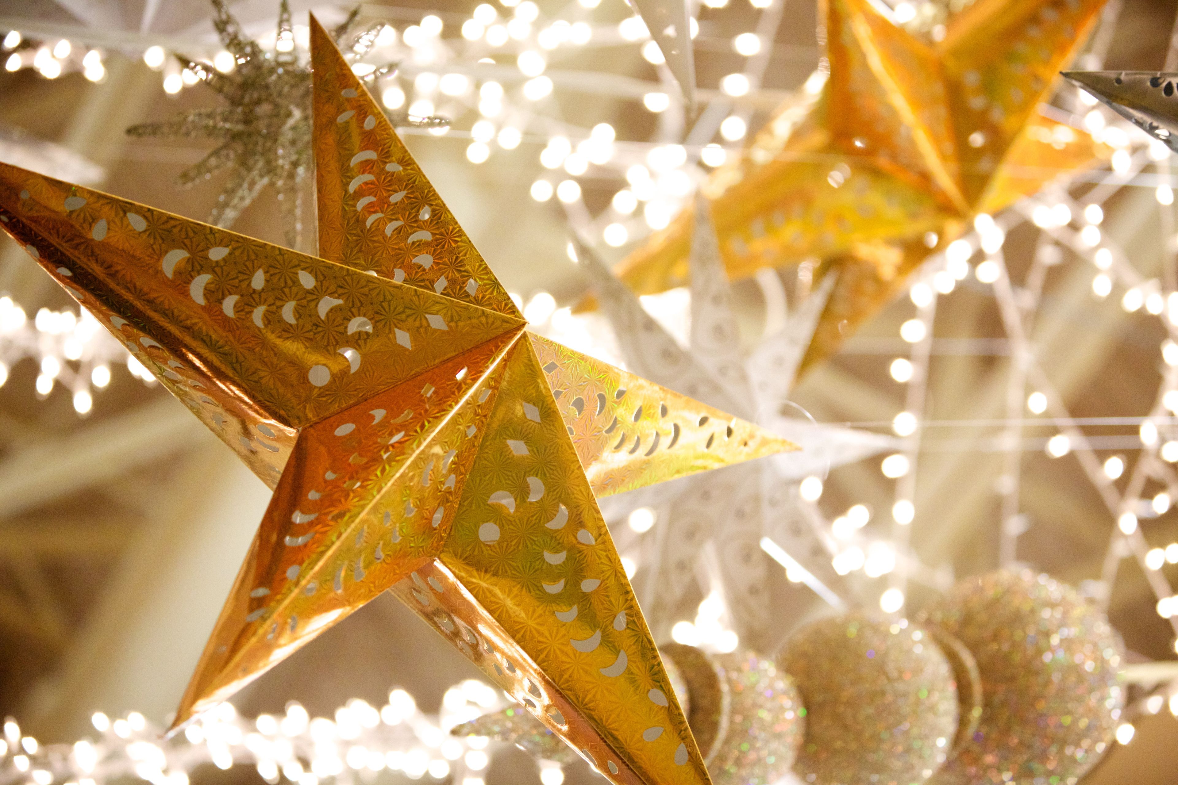 Some gold foil stars hang as part of a Christmas decoration display.