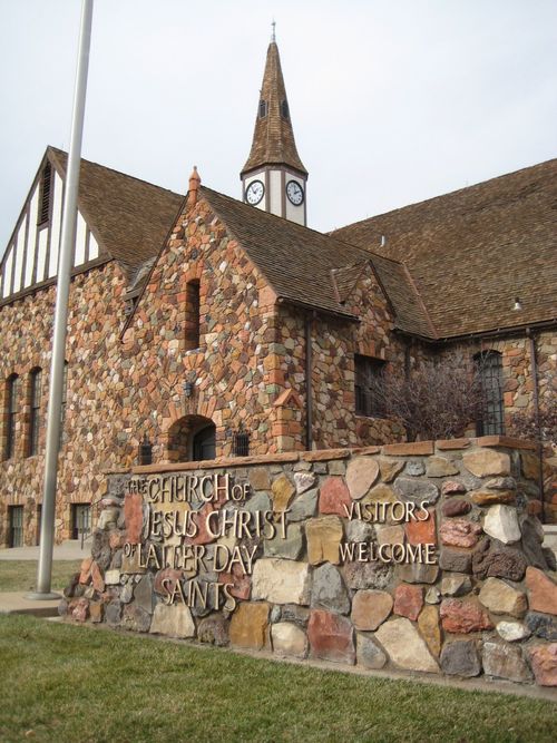 An old rock chapel with a steeple and a sign in the front that says “The Church of Jesus Christ of Latter-day Saints, Visitors Welcome” in Cedar City.