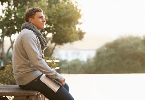 young man sitting on bench outside