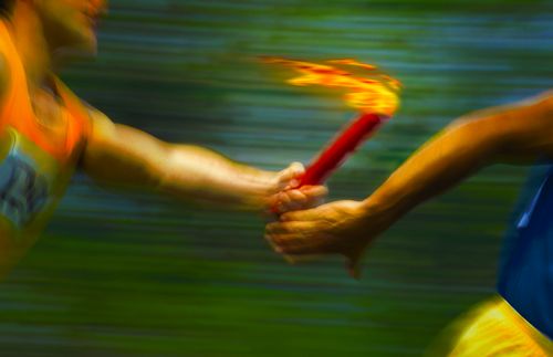 Runners passing a torch.