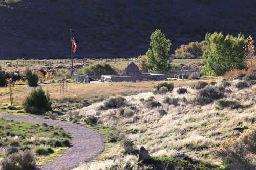 The large stone cairn at the Mountain Meadows Massacre site, with an American flag nearby.