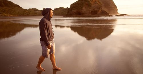 young man walking on beach