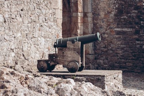 A cannon outside of a stone wall