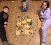 Three children with a temple made of plastic blocks