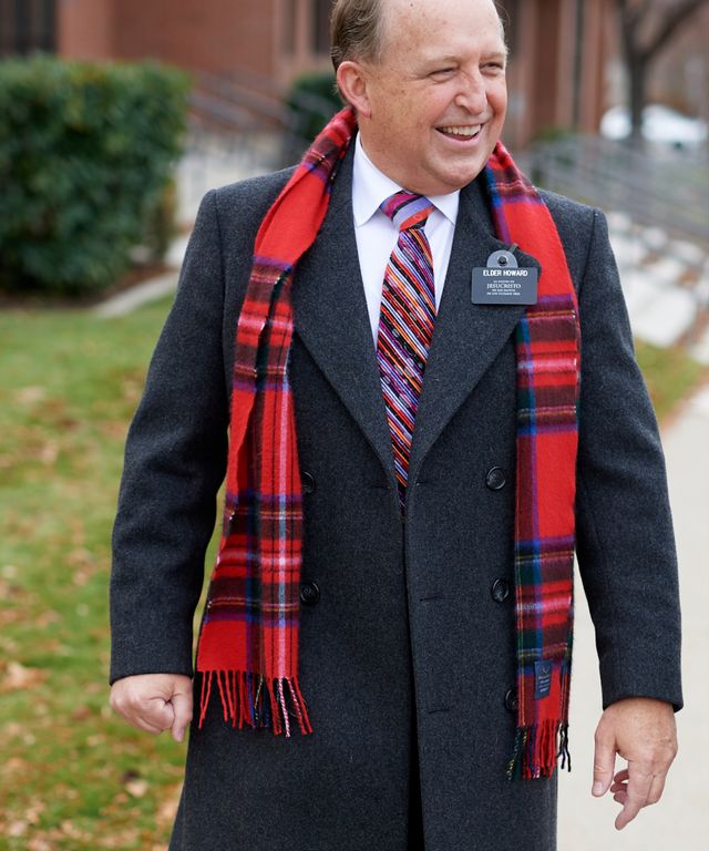 A senior missionary models appropriate dress and attire. He is wearing an approved overcoat, tie, scarf, and shoes.