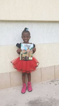 girl in red tutu holding copy of the Friend magazine